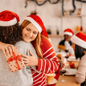 A woman hugs another woman after receiving a present