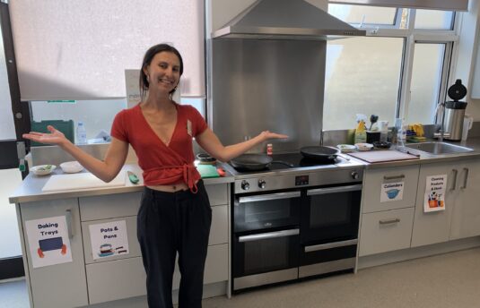 CTS Volunteer posing and smiling in our day centre's kitchen