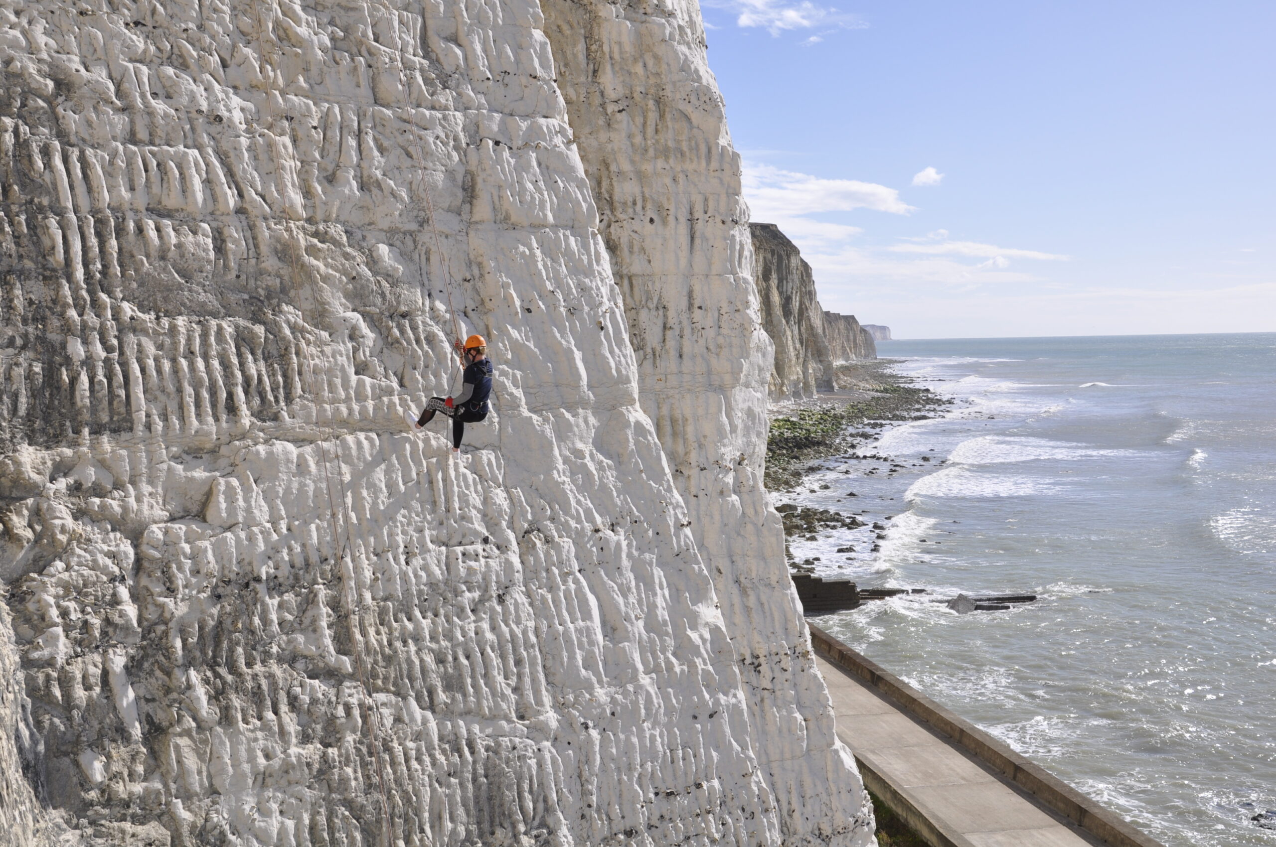 A photo of a person abseiling down the Peacehaven Cliffs