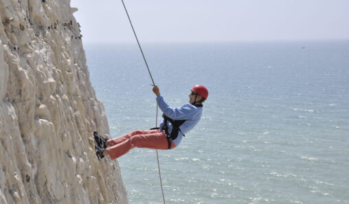 A photo of a person abseiling down the Peacehaven Cliffs