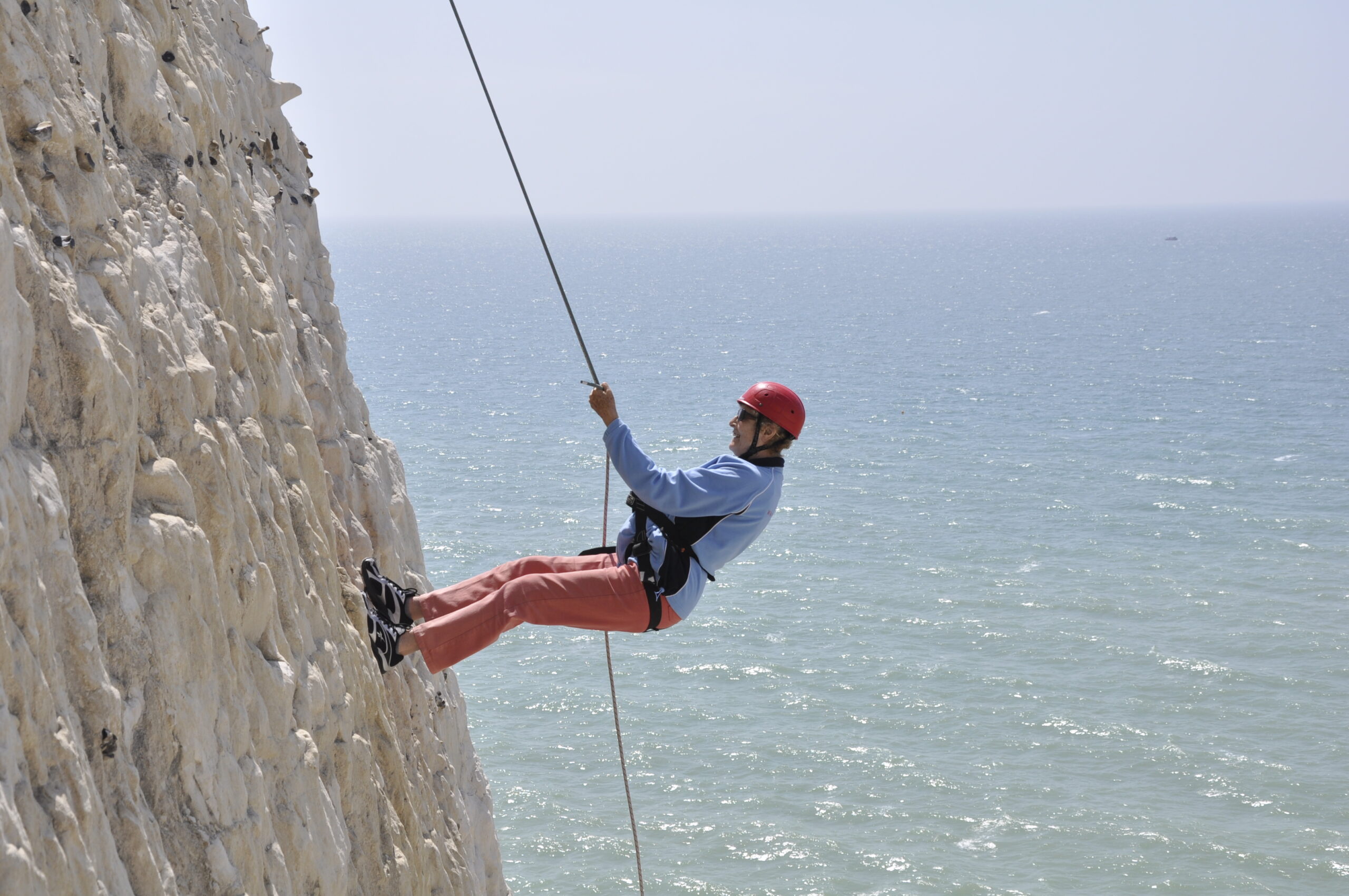 A photo of a person abseiling down the Peacehaven Cliffs